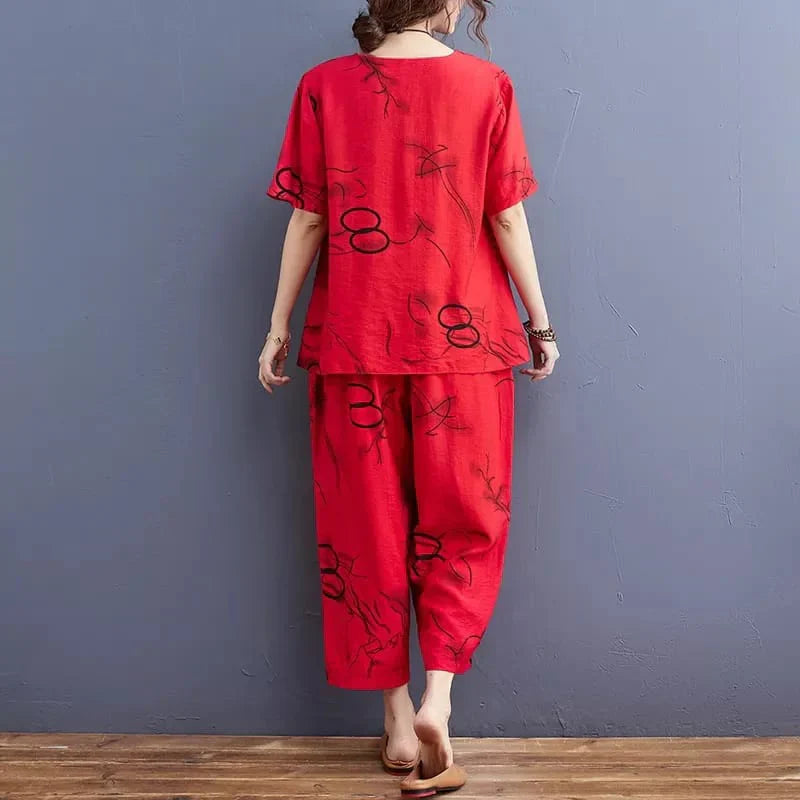 Person wearing a red outfit with black patterns against a gray wall.