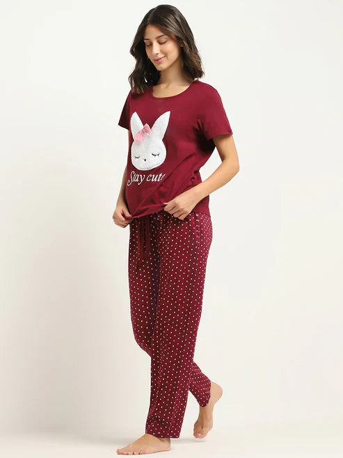 Woman wearing a maroon pajama set with a bunny design on a white background
