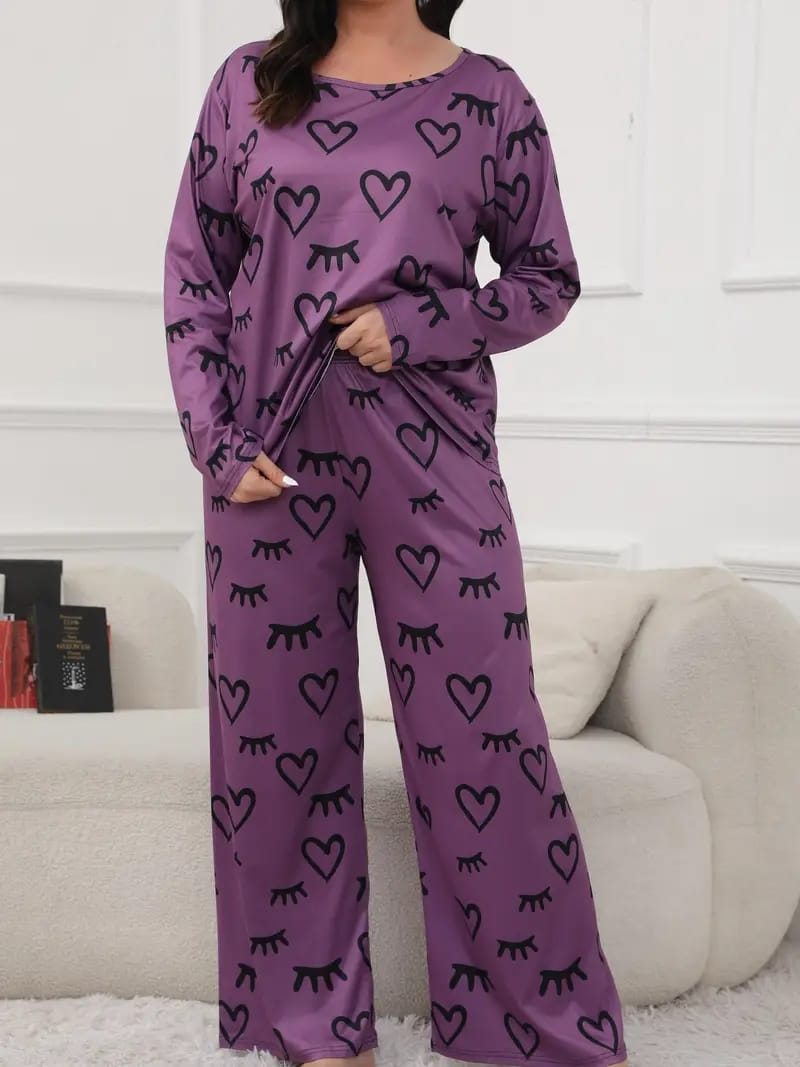 Purple pajama set with black heart and eye patterns worn by a person in a living room.
