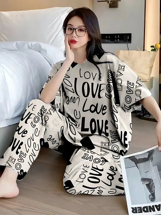 Woman wearing a 'LOVE' printed outfit sitting on a bed.