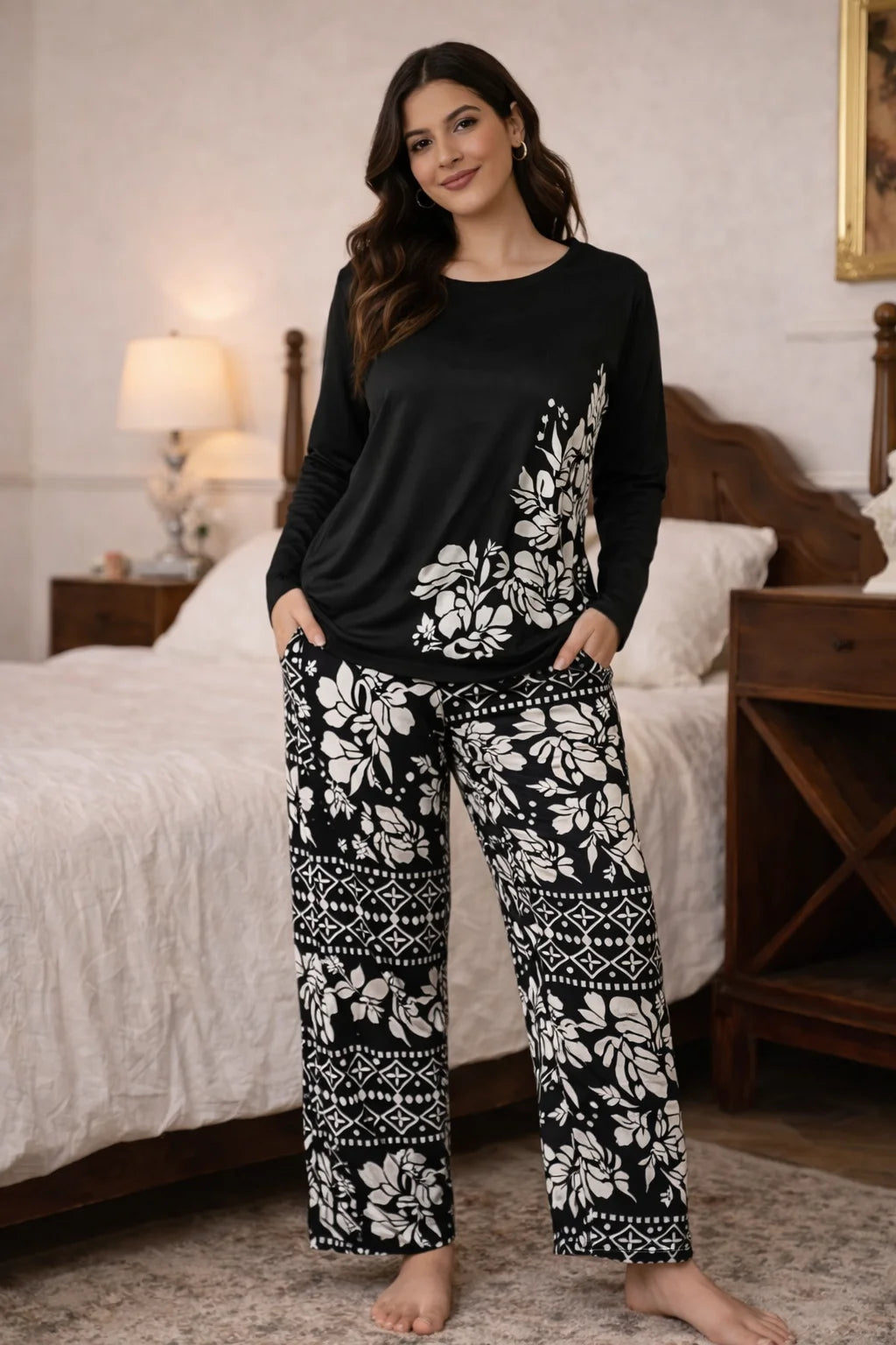 Woman wearing a black and white patterned pajama set in a bedroom.