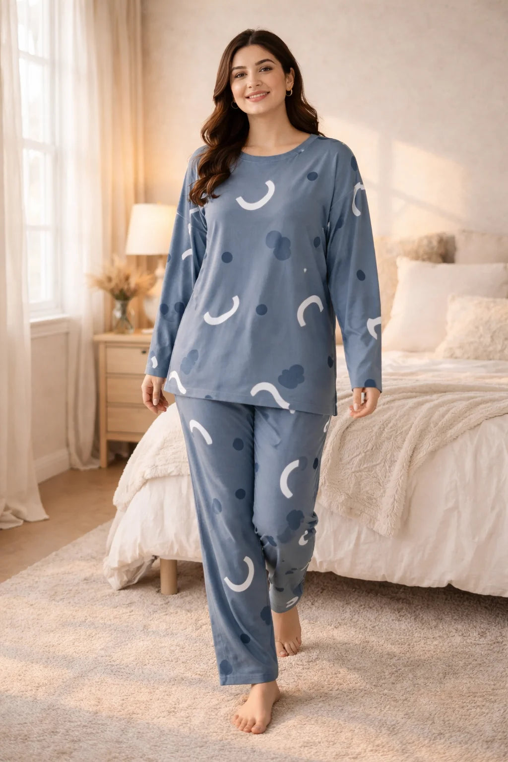 Woman wearing blue pajamas with white patterns in a bedroom setting