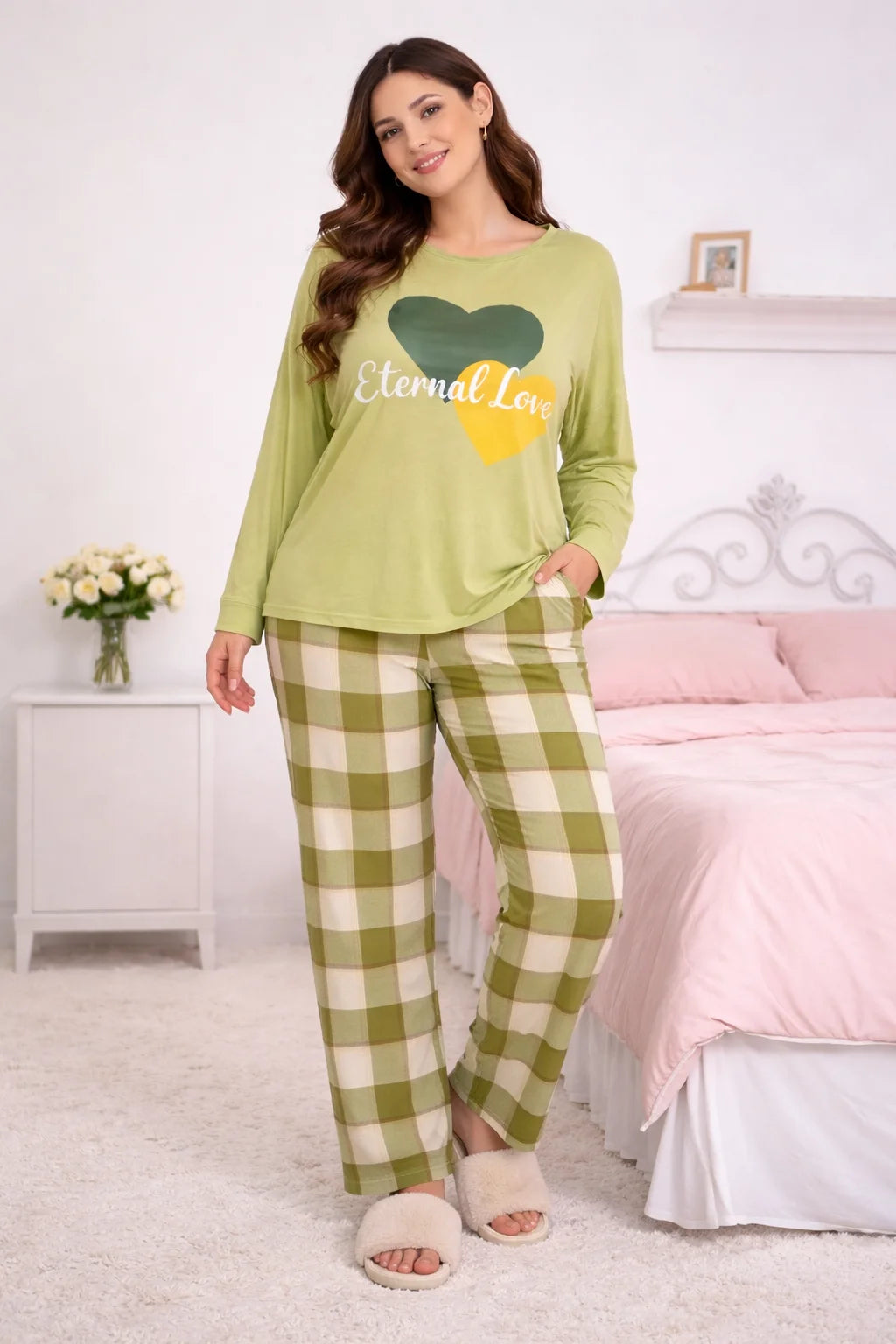 Woman wearing a green pajama set with a heart design in a bedroom.