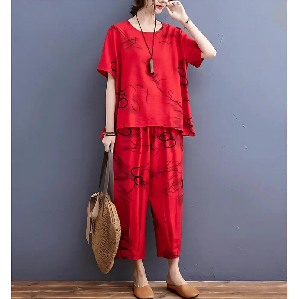 Person wearing a red outfit with black patterns against a gray wall