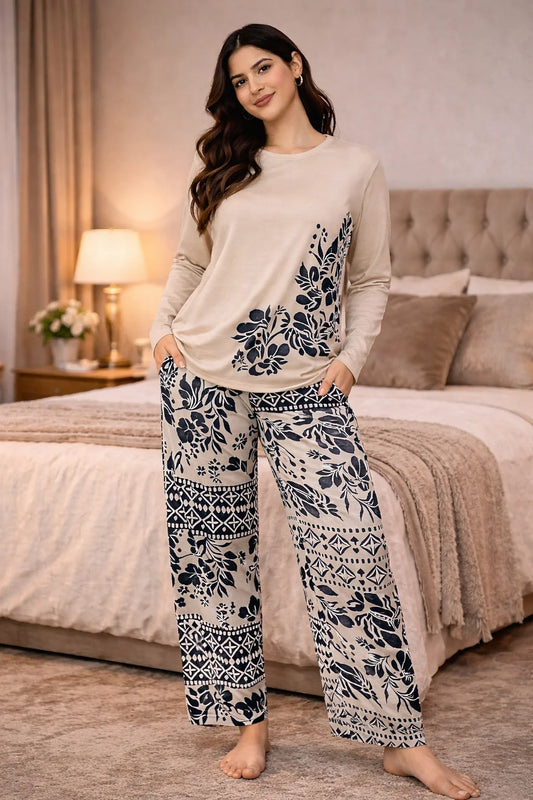 Woman wearing a beige top and black and white patterned pants in a bedroom setting.
