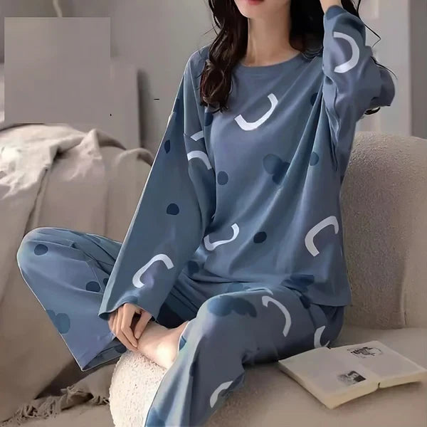 Person wearing a blue pajama set with white patterns sitting on a couch.